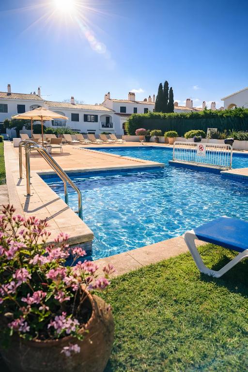 a swimming pool with a patio and an umbrella at Magda - Cala En Porter in Cala en Porter