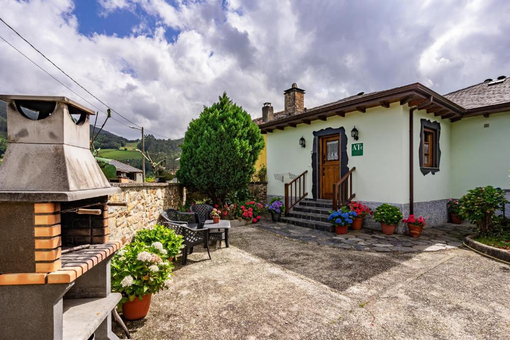 ein kleines weißes Haus mit Veranda und einem Gebäude in der Unterkunft Maseda 2 in Villayón