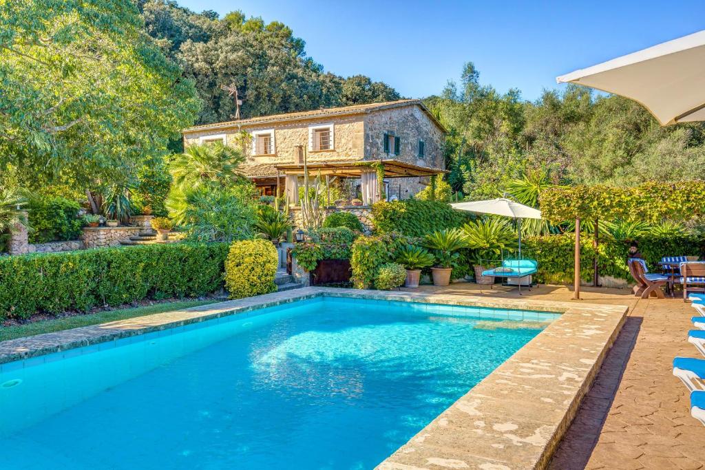 a swimming pool in front of a house at Ca les Estamenyes in Pollença