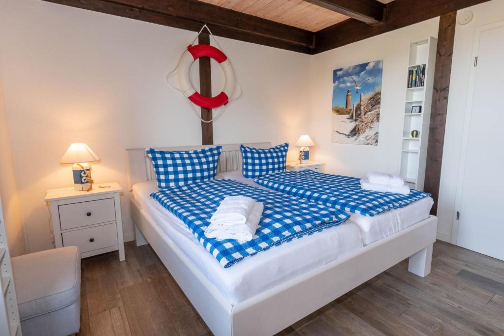 a bedroom with a bed with blue and white sheets at Ferienwohnung Strandgut in Pellworm