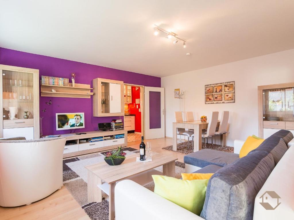 a living room with a purple accent wall at Ferienwohnung Knopf in Schömberg