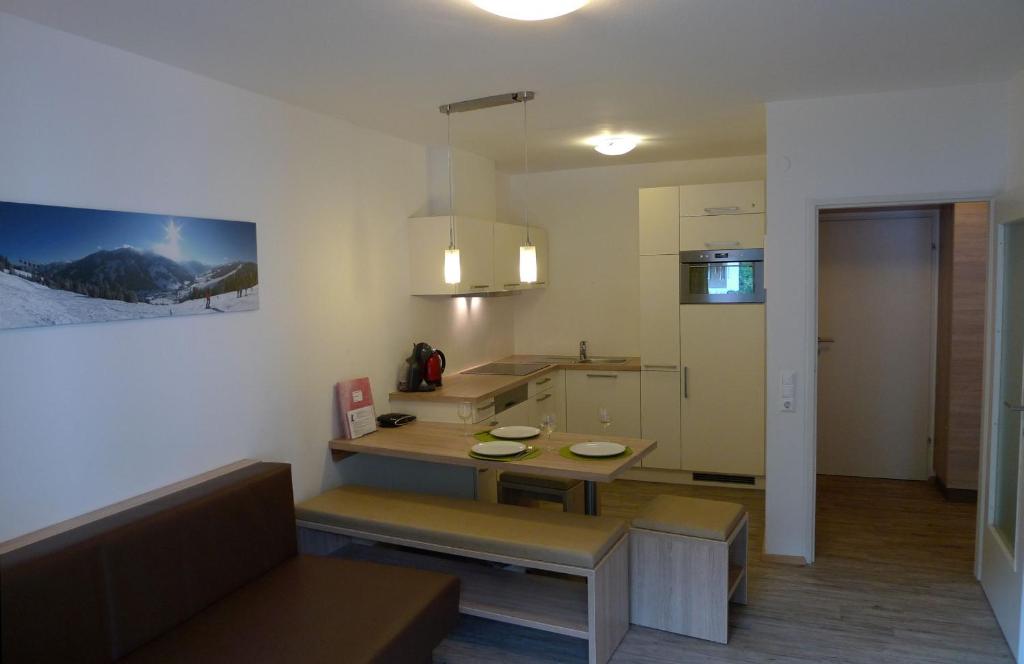eine kleine Küche mit einem Tisch und einem Kühlschrank in der Unterkunft Ferienwohnung Loitfelder-Pang in Saalbach-Hinterglemm