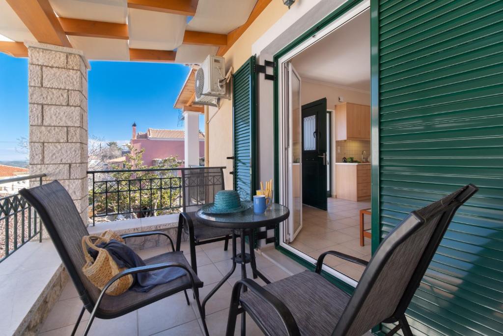 a patio with a table and chairs on a balcony at Villa Votistis A1 in Lefkada