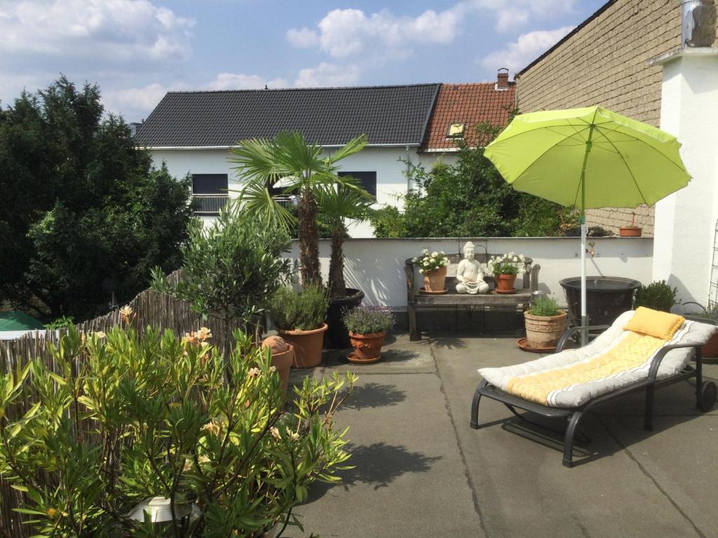 a patio with a green umbrella and some plants at Ferienwohnung Beletage mit Terrasse in Neuwied