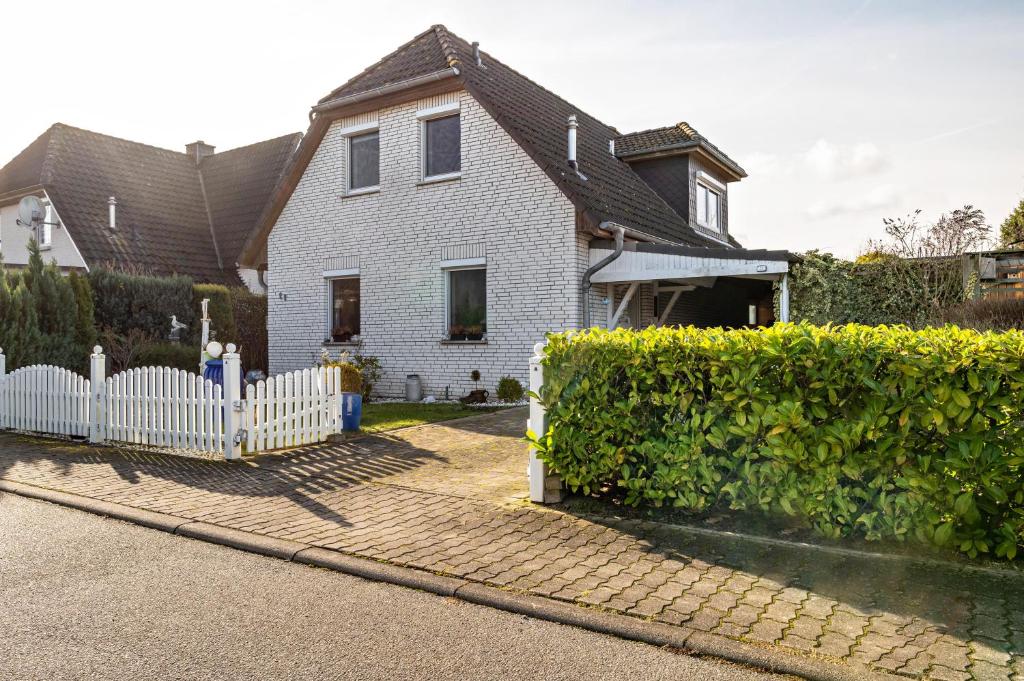 a white house with a white picket fence at Ferienhaus Nahe Ostsee in Rövershagen