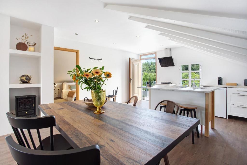 a dining room table with a vase of flowers on it at Casa da Olides - T3 and Studio in Santana