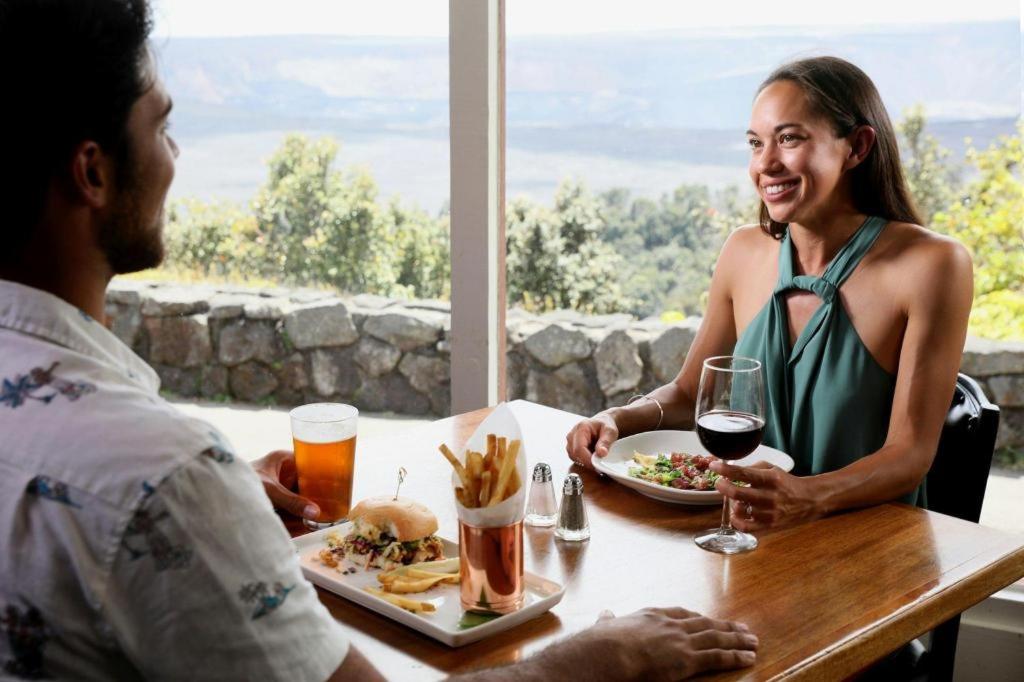 a man and woman sitting at a table with a plate of food at Volcano House in Volcano
