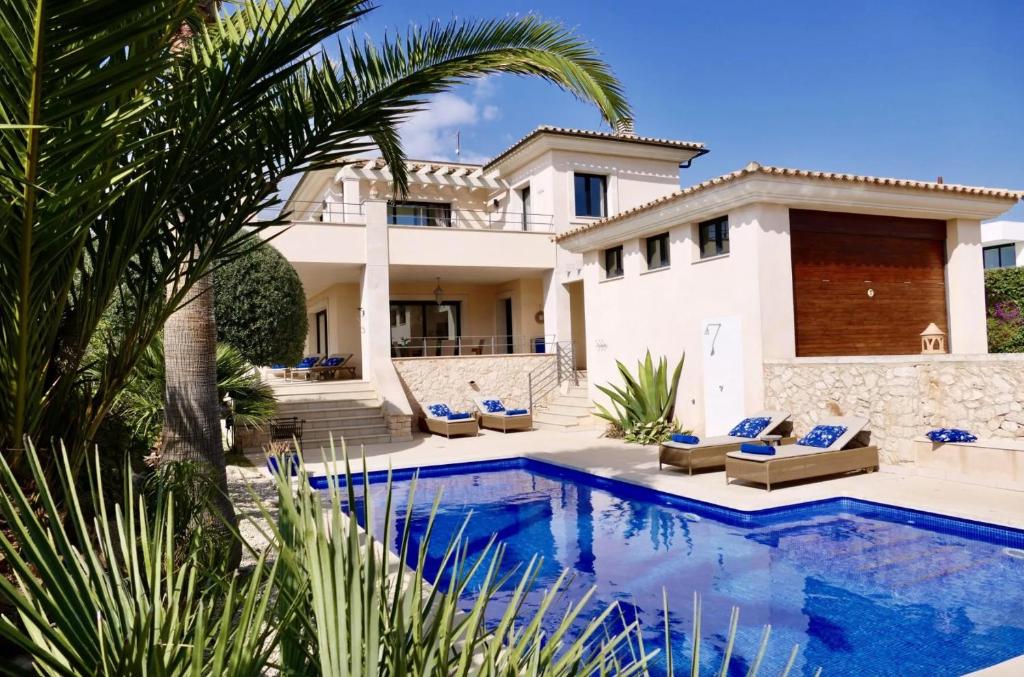 a villa with a swimming pool and a house at Ocean Blues in Cala Santanyi