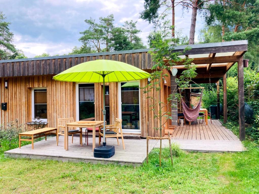 a wooden deck with a table and a yellow umbrella at Bungalow 314 in Joachimsthal