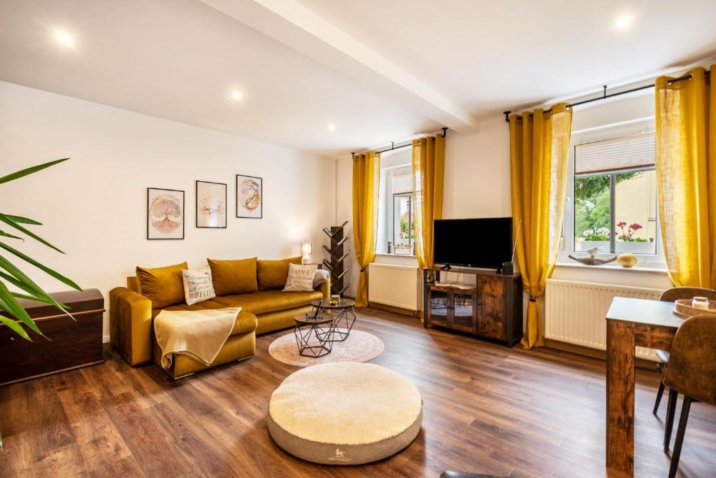 a living room with a couch and a tv at Gästewohnung Auszeit in Regis-Breitingen