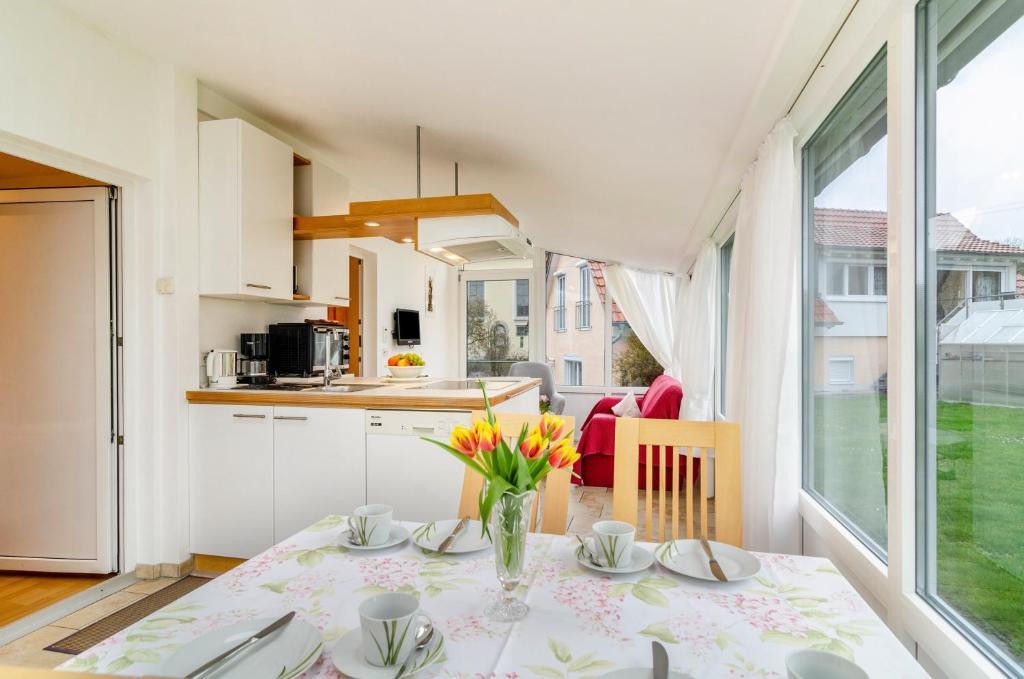 a kitchen and dining room with a table with flowers at Haus Nussbaum in Hödingen