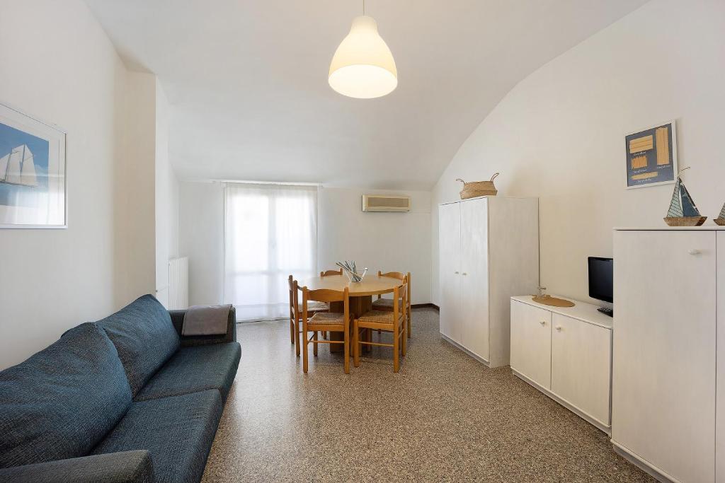 a living room with a blue couch and a table at Appartamento Orizzonte 8 B in Diano Marina