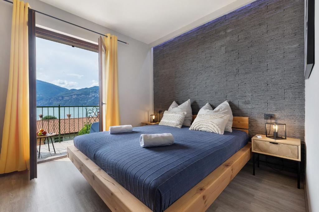 a bedroom with a large bed with a brick wall at New Casa Di Tino in Brenzone sul Garda