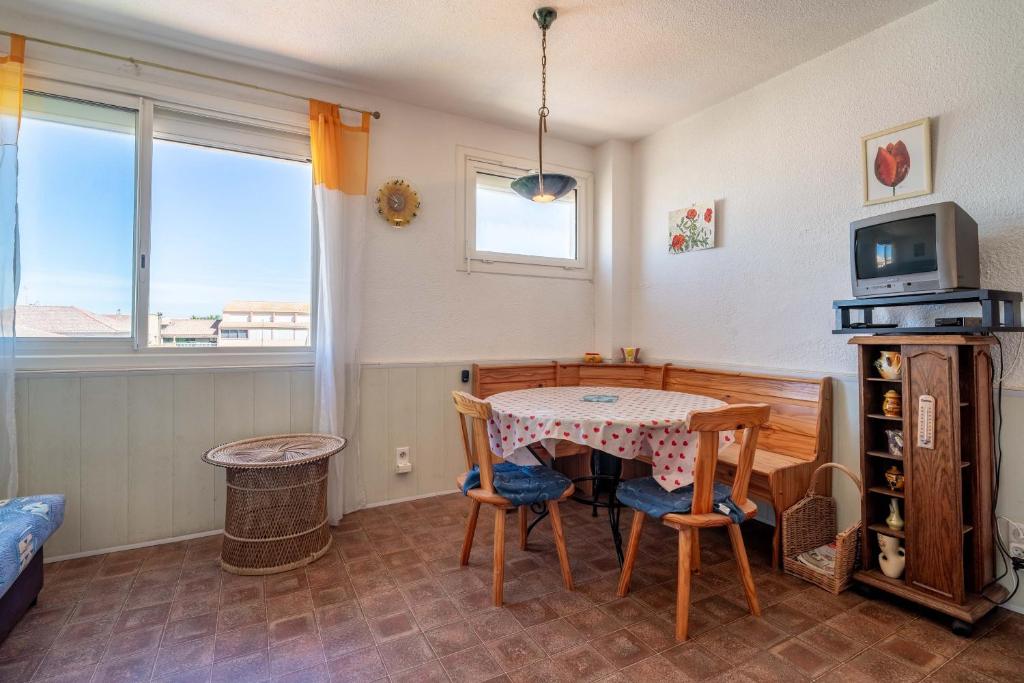 a room with a table and chairs and a television at Grand Hotel Studio in Valras-Plage