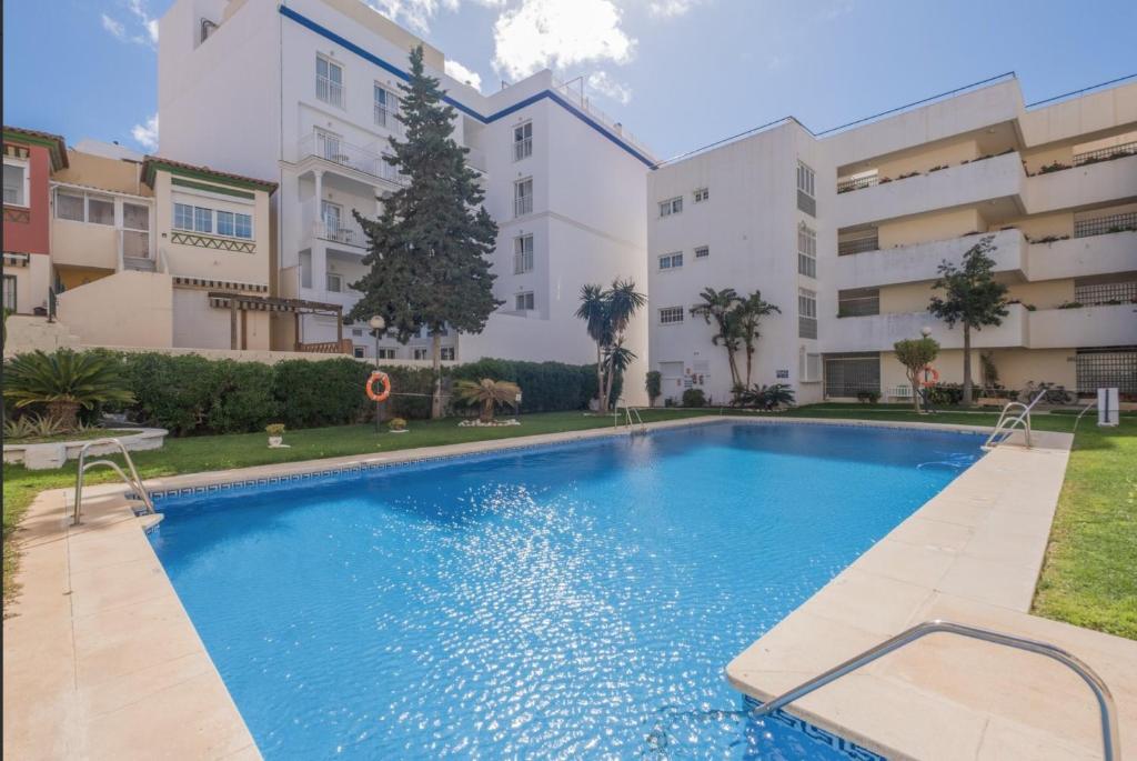 a swimming pool in front of a building at Flat3-5 Chaparil Beach in Nerja