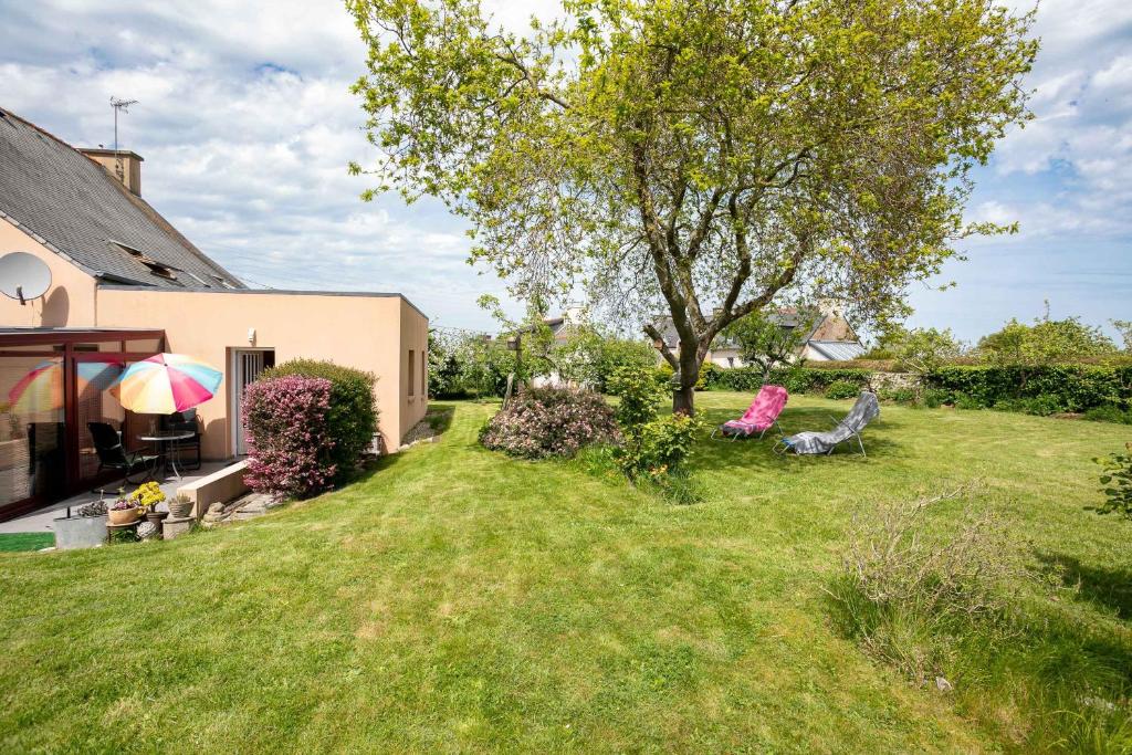 a yard with a tree and a house at Gîte Proche Mer 800 m in Plouézec