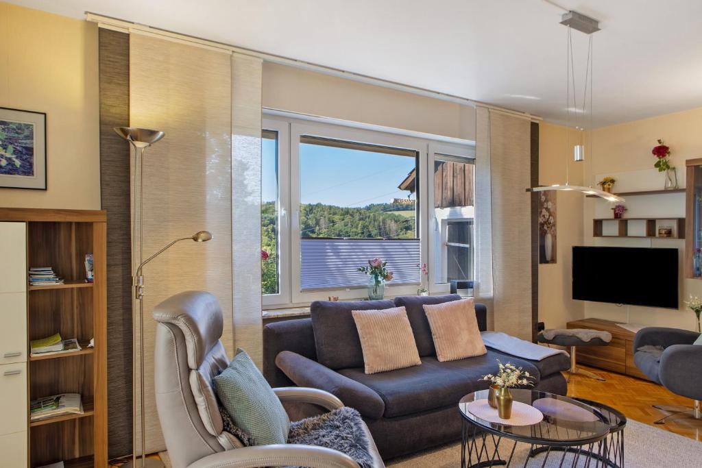 a living room with a couch and a large window at Ferienwohnung Fuldatalblick in Fulda