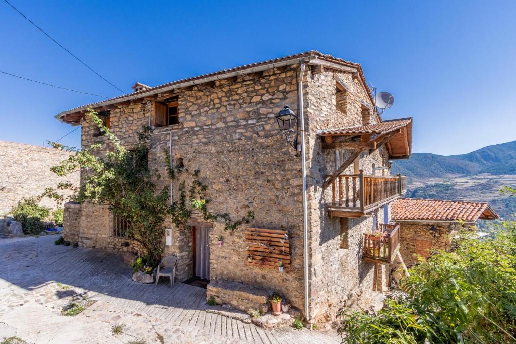an old stone house with a balcony on a hill at Cal Barral in Ansobell