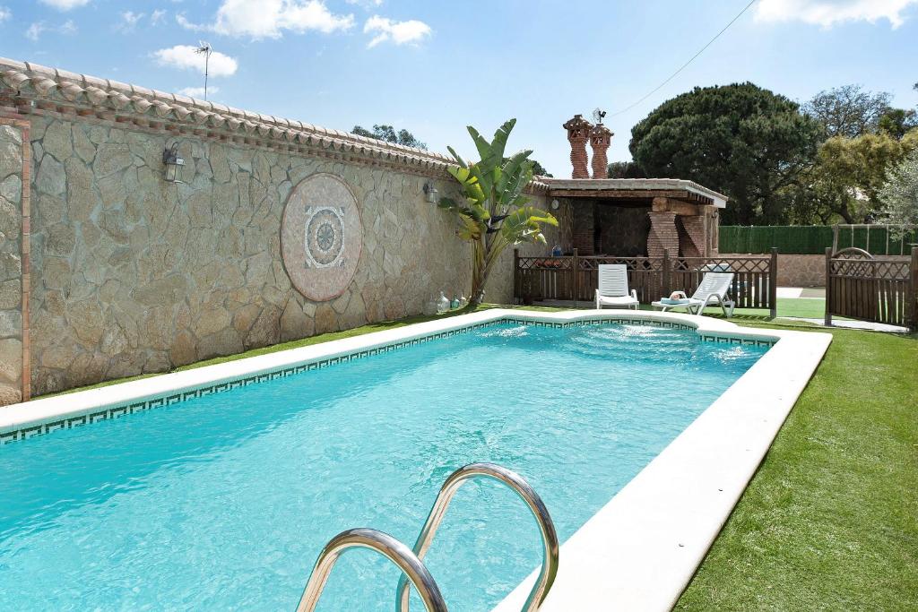 a swimming pool in a yard next to a wall at Villa Africa in La Muela