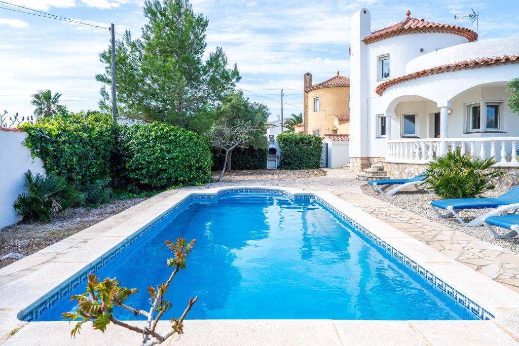 a swimming pool in front of a house at Villa Flor in Les tres Cales