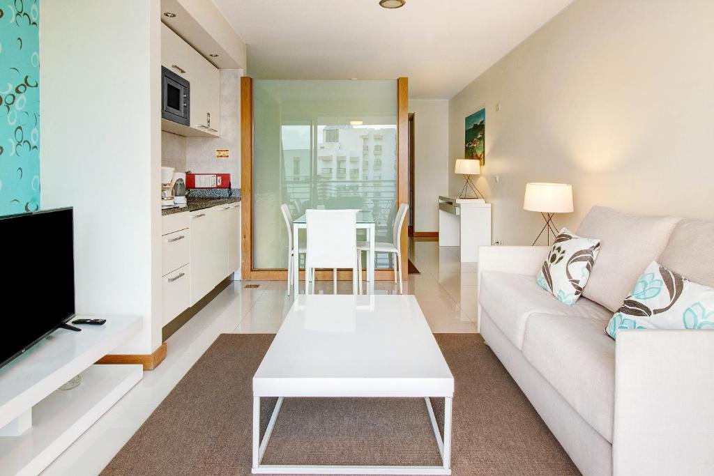 a living room with a white couch and a table at Dfm Happy Days C - Funchal in Funchal