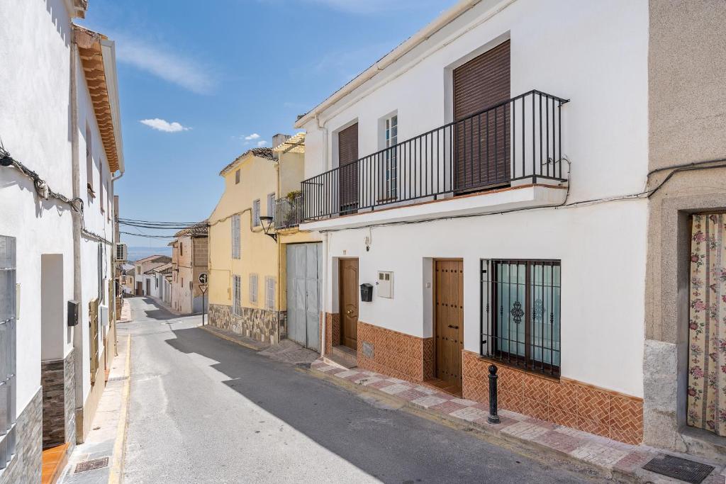 an empty street in an alley with buildings at Casa Petra in Illora