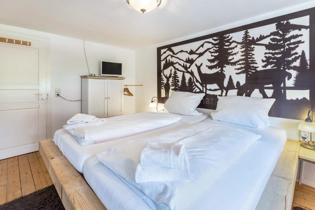 a large white bed in a room with a wall at Haus Steinatal in Ühlingen-Birkendorf