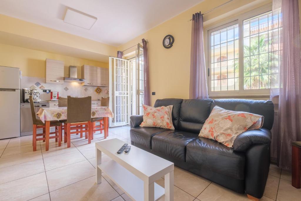 a living room with a leather couch and a table at Casa a 100 mt Dal Mare in SantʼAlessio Siculo