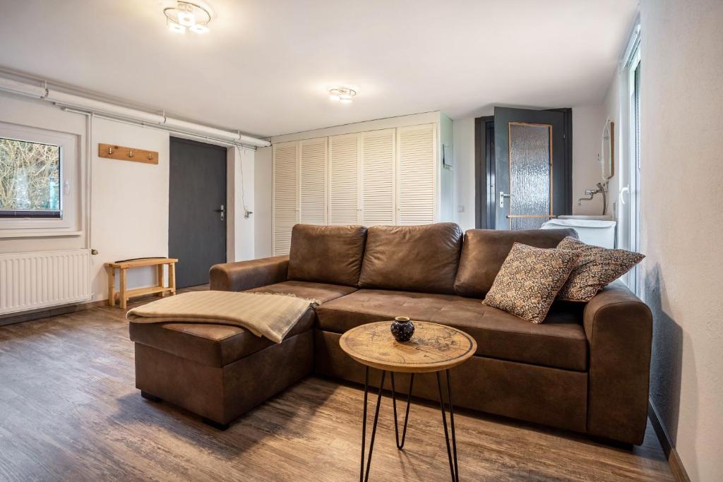 a living room with a brown couch and a table at Ferienwohnung Kropp in Knorrendorf
