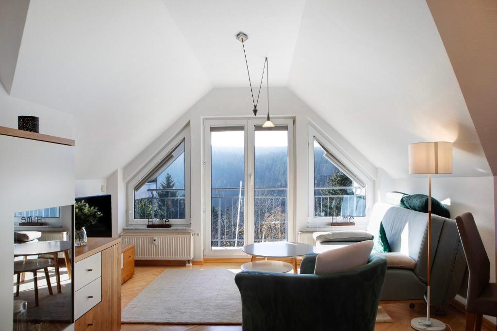 a living room with a bed and a table and some windows at Ferienwohnung Tannenblick 7-5 in Oberhof