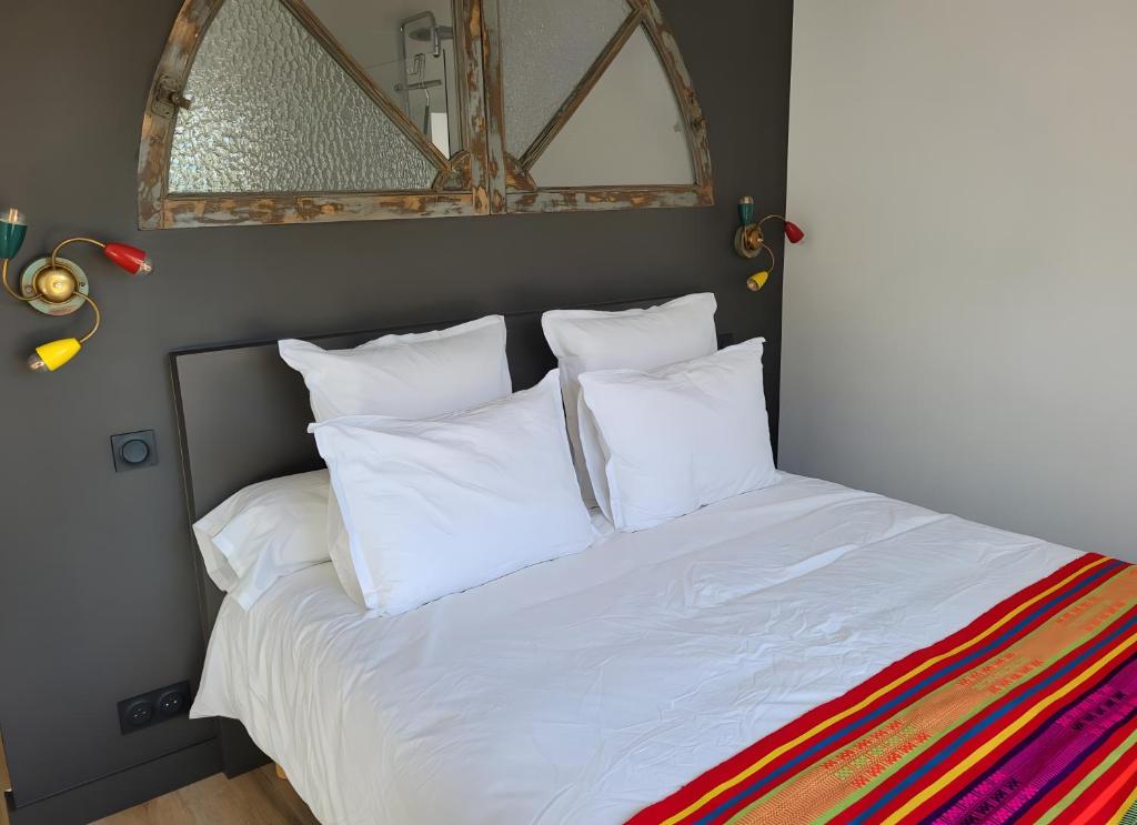 a bed with white sheets and pillows in a bedroom at Chambre D'hôtes À 2 Pas Des Plages in Notre-Dame-de-Riez