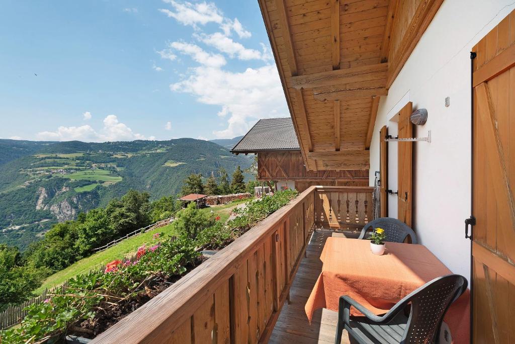 a balcony of a house with a table and chairs at Stinerhof Panoramablick in Vols am Schlern