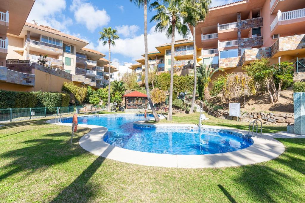 a swimming pool in front of a apartment building at Lovely Apartment Higueron in Benalmádena