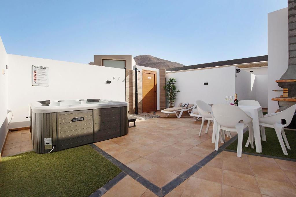 a patio with white walls and a table and chairs at Eclipse in Puerto del Rosario