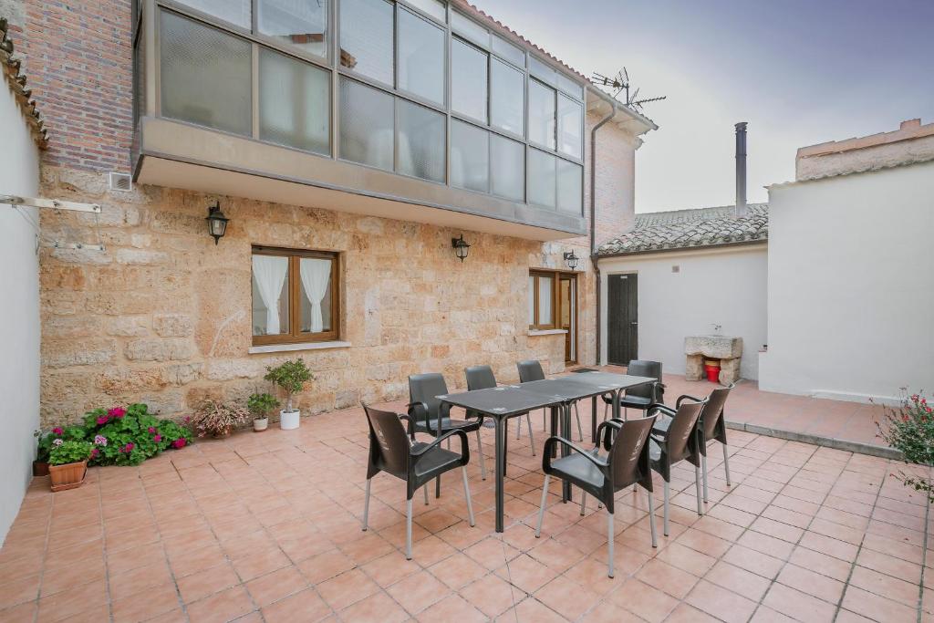 a patio with a table and chairs and a building at El Humilladero in Sasamón