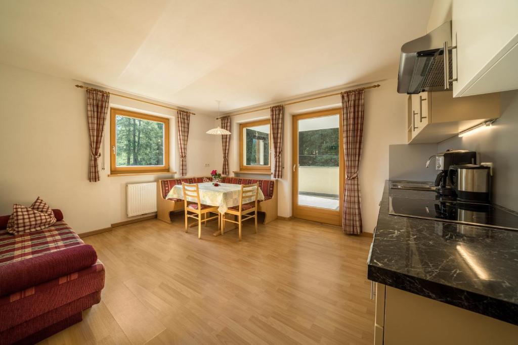 a kitchen and a living room with a table at Ferienhaus Maria Arnika in Moso