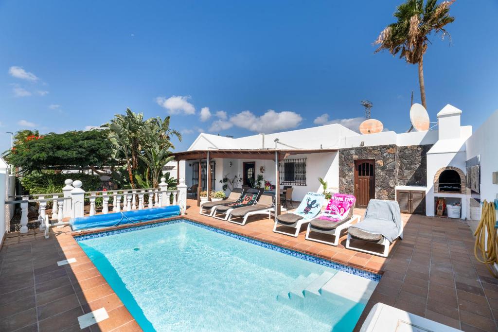 a villa with a swimming pool and a house at Casa Colleen in Puerto del Carmen