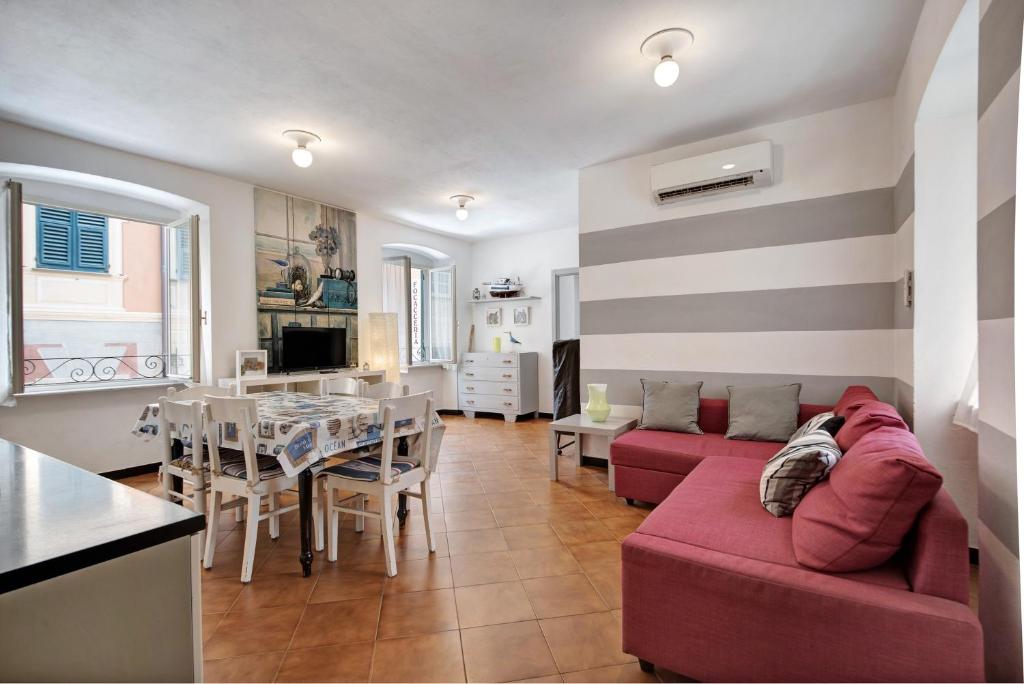 a living room with a red couch and a table at Oceane Paradise - Churchill in Levanto