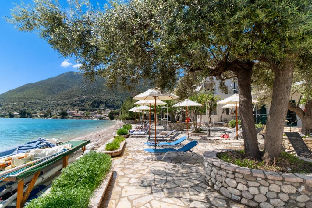 a beach with chairs and umbrellas and the water at Nikiana Club - Studio 1 in Nikiana