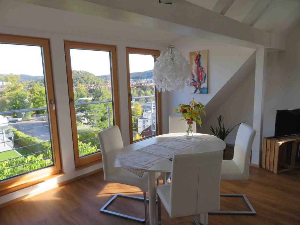 a dining room with a white table and white chairs at Straussi´s Loft in Tuttlingen