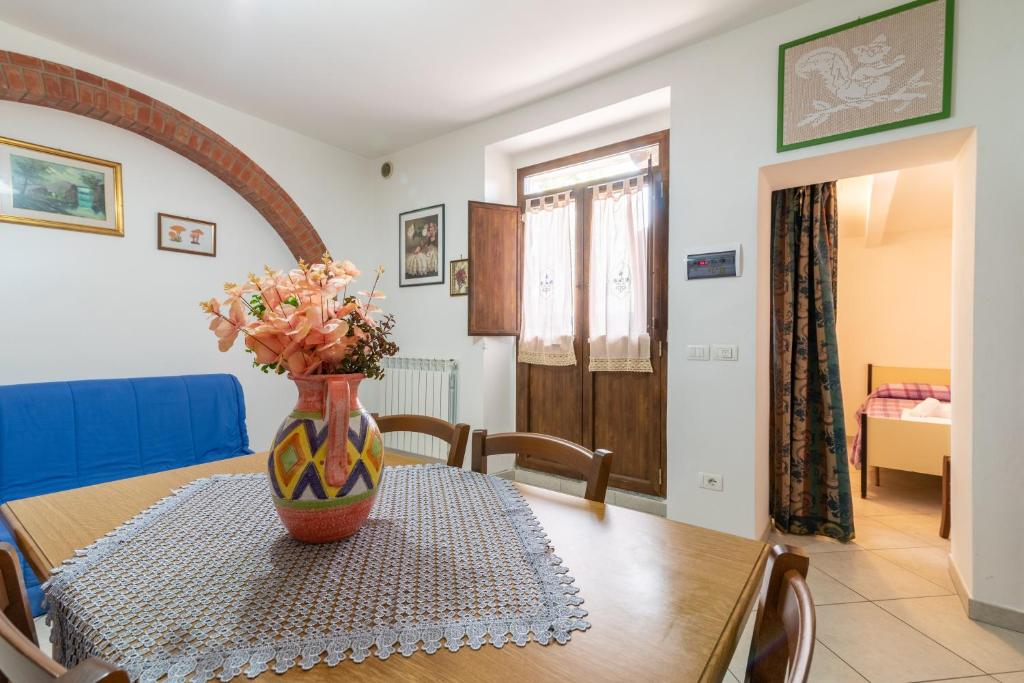 a vase with flowers on a table in a room at Papà Giuseppe La Stalla in Cortona