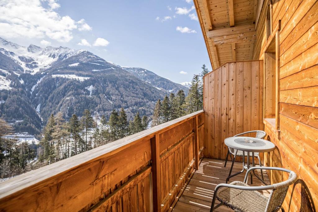 a wooden balcony with a table and chairs on it at Golserhof Kristall in Cadipietra