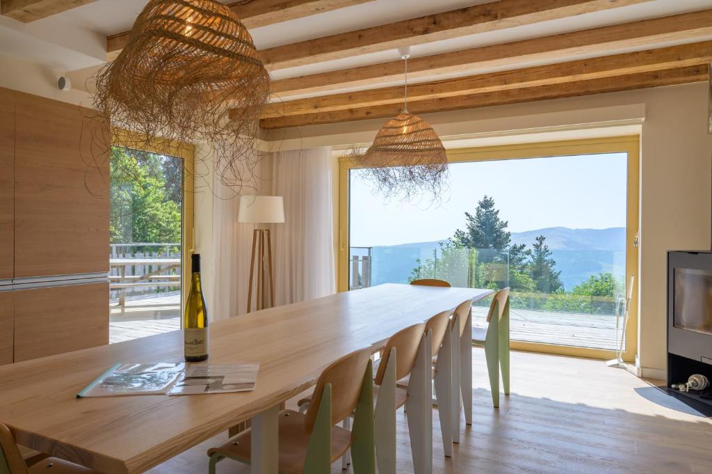 a dining room with a long table and a large window at Refuge Mil100 Chalet-spa Luxe 5 in Metzeral