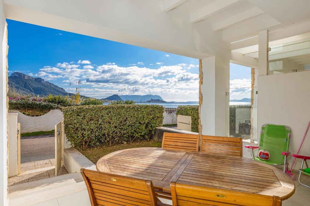 a table and chairs on a patio with a view of the ocean at Residenza Cormorani 2 in Golfo Aranci