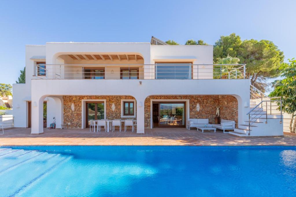 a villa with a swimming pool and a house at Casa Once Moraira in Teulada