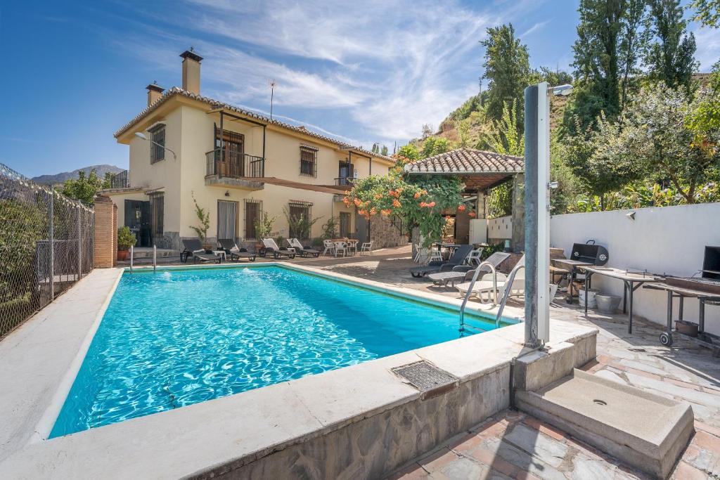 a swimming pool in front of a house at Casa Hitos in Monachil