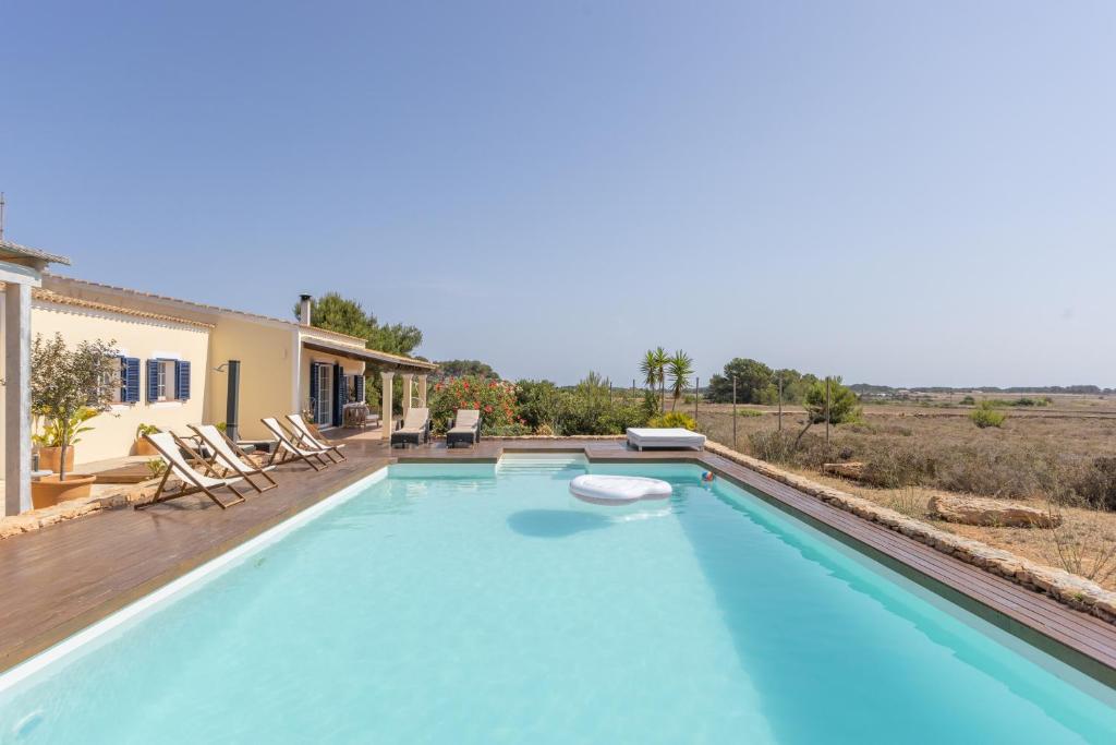 a large pool with a deck and a house at Can Juan Pedro in La Mola