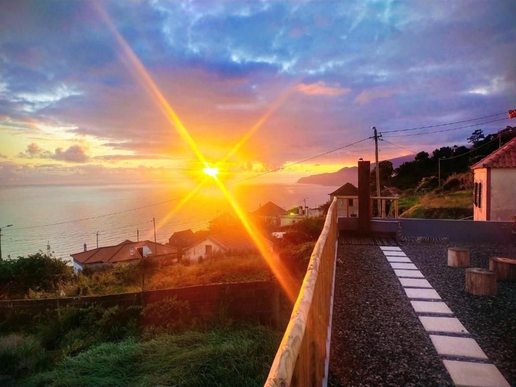 a view of the sunset from a balcony of a house at Casa da Ribeira da Janela in Porto Moniz