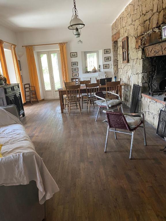 a living room with chairs and a stone wall at Buvolaccia in Sampolo