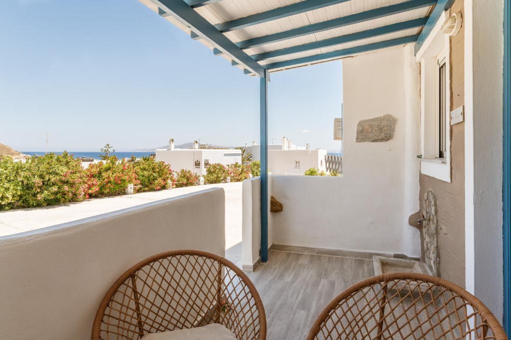 a balcony with two chairs and a view of the ocean at Porto Galini Kalloni in Agios Ioannis